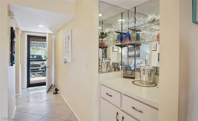 bar with light tile flooring and white cabinetry