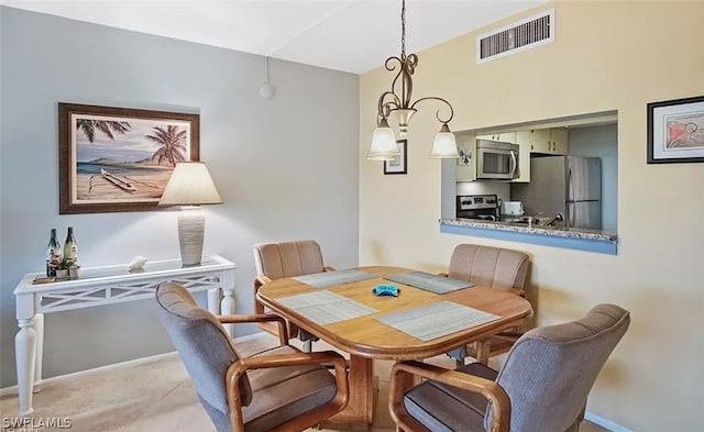 dining space with a chandelier and light colored carpet