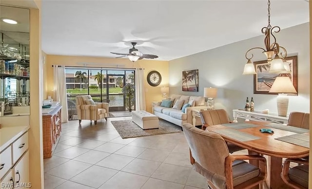 tiled living room with ceiling fan with notable chandelier