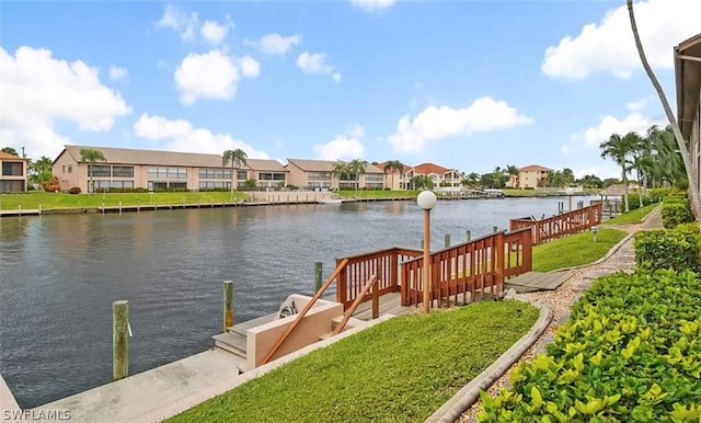 dock area featuring a water view and a lawn