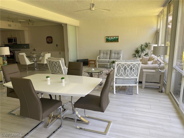 dining space featuring ceiling fan, a healthy amount of sunlight, and a textured ceiling