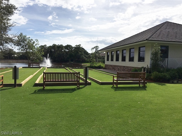 view of community with a lawn and a water view