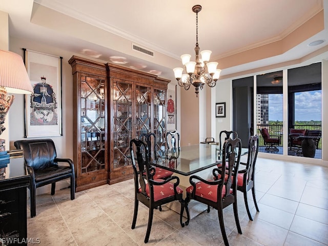 dining space featuring an inviting chandelier, a raised ceiling, and ornamental molding