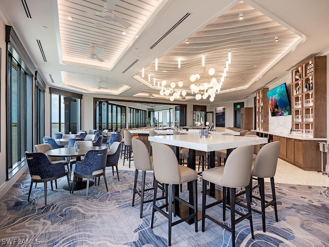 dining space featuring a chandelier, a tray ceiling, and wooden ceiling