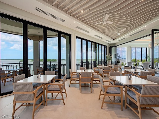 dining space with a water view and light tile patterned flooring