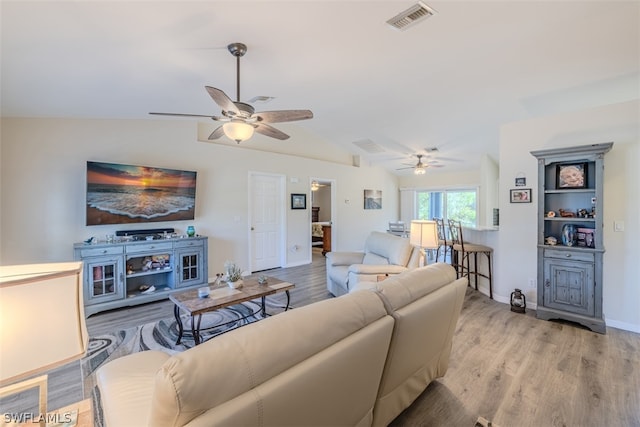 living room featuring lofted ceiling, ceiling fan, and light hardwood / wood-style flooring