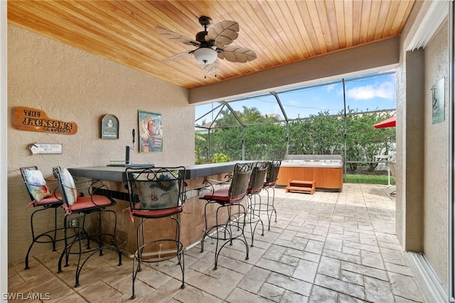 sunroom with ceiling fan, plenty of natural light, and wooden ceiling