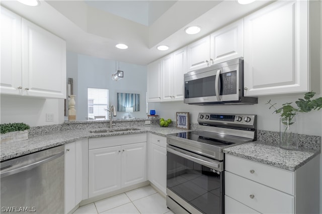 kitchen featuring white cabinetry, stainless steel appliances, sink, and light stone counters