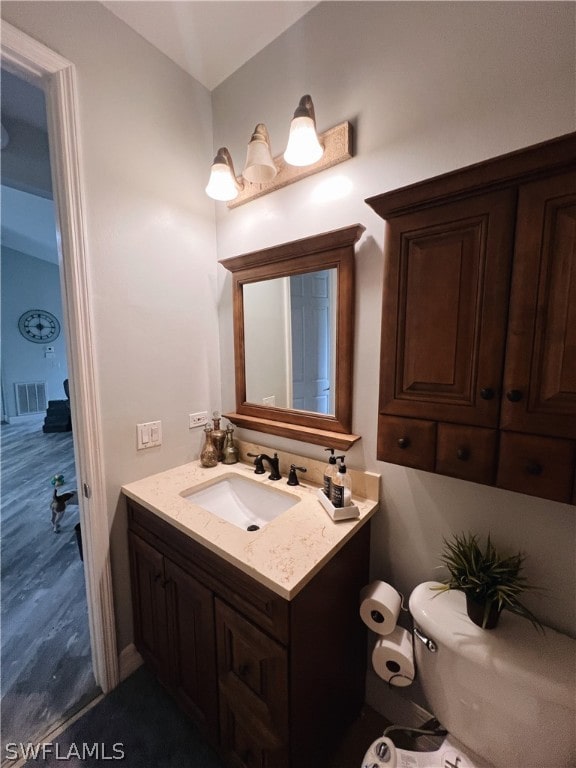 bathroom featuring toilet and large vanity