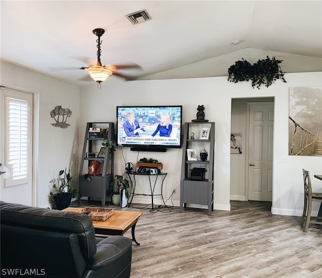 living room featuring lofted ceiling, ceiling fan, and light wood-type flooring