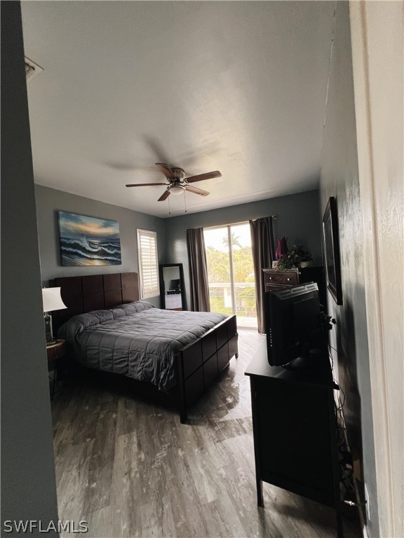 bedroom with hardwood / wood-style floors, ceiling fan, and access to exterior