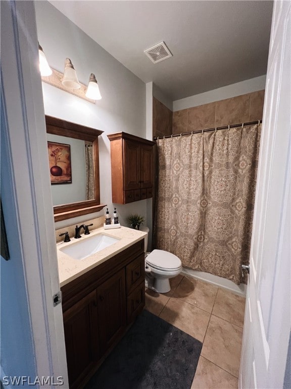 bathroom featuring tile flooring, vanity, and toilet