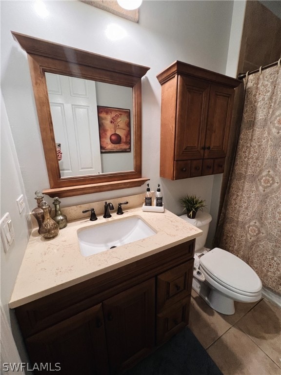 bathroom featuring tile flooring, vanity, and toilet