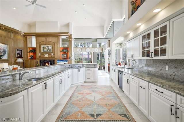 kitchen featuring white cabinets, stone countertops, and sink