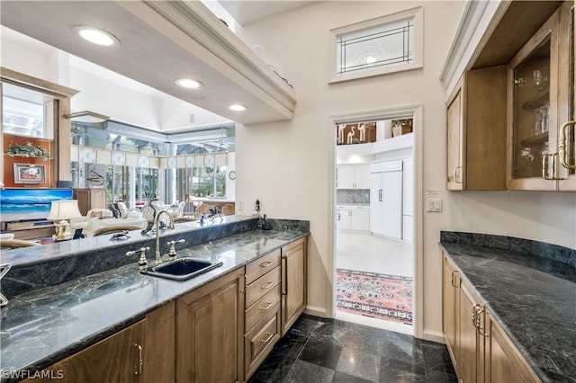 kitchen featuring plenty of natural light, dark stone counters, and sink