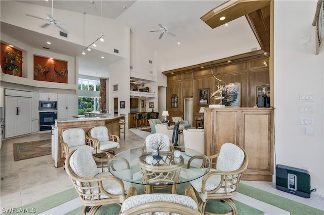 dining space with light tile patterned floors and high vaulted ceiling