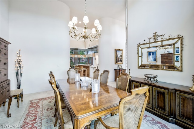 tiled dining space with a towering ceiling and an inviting chandelier