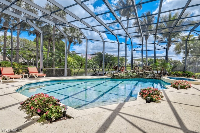 view of pool featuring an in ground hot tub, glass enclosure, and a patio area