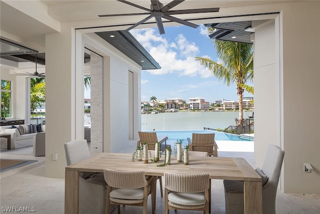 view of patio with a water view, ceiling fan, outdoor dining area, and a fenced in pool