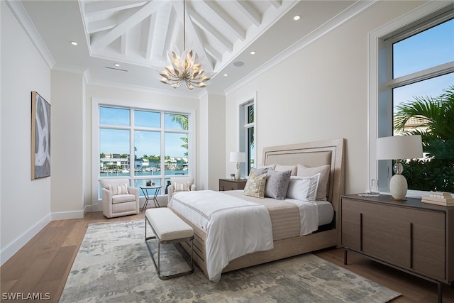 bedroom with a high ceiling, multiple windows, wood finished floors, and crown molding