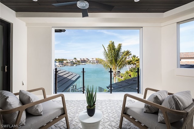 balcony with ceiling fan and a water view