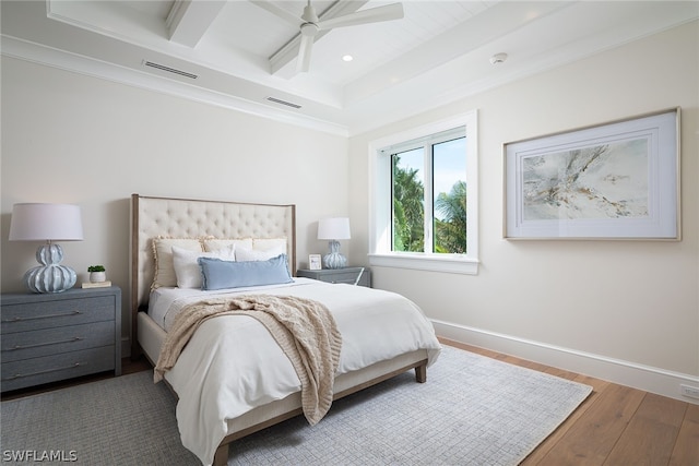 bedroom featuring baseboards, visible vents, wood finished floors, and beamed ceiling