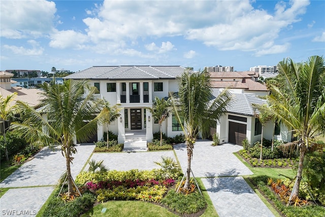 view of front of house with an attached garage, decorative driveway, and stucco siding