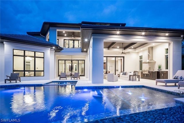 back of property featuring exterior kitchen, a ceiling fan, a patio, and stucco siding