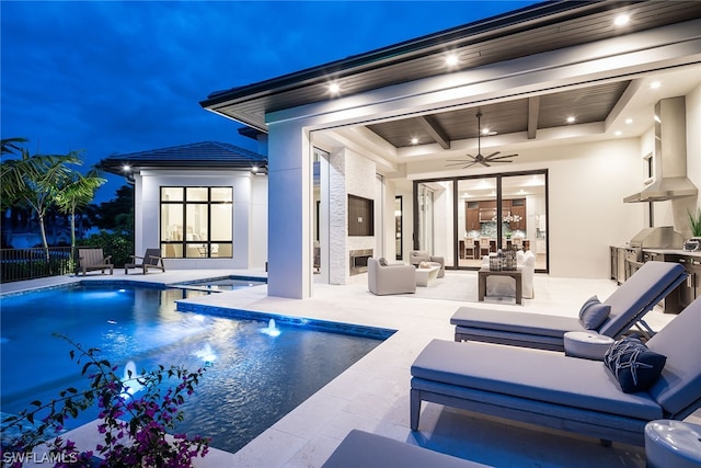 rear view of house with stucco siding, ceiling fan, an outdoor living space, and a patio