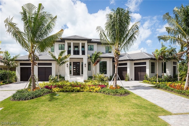 prairie-style house featuring stucco siding, decorative driveway, and a front yard