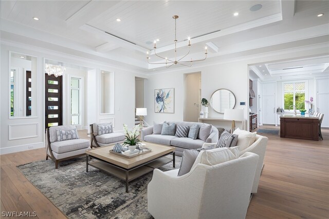 living room featuring light wood-type flooring, beam ceiling, ornamental molding, and a notable chandelier