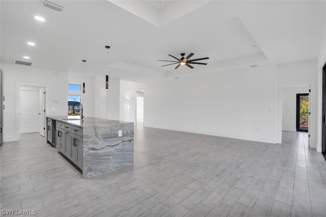 kitchen featuring light stone countertops, light hardwood / wood-style flooring, a healthy amount of sunlight, and decorative light fixtures