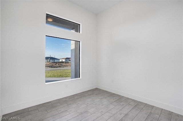 empty room featuring baseboards and wood finished floors