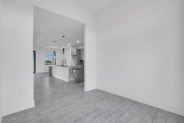 interior space featuring white cabinets, sink, and light hardwood / wood-style flooring