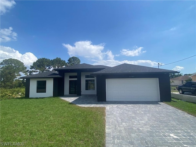 view of front of home with a garage and a front lawn