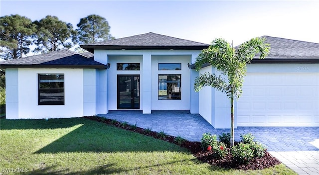 exterior space featuring roof with shingles, stucco siding, french doors, a yard, and an attached garage