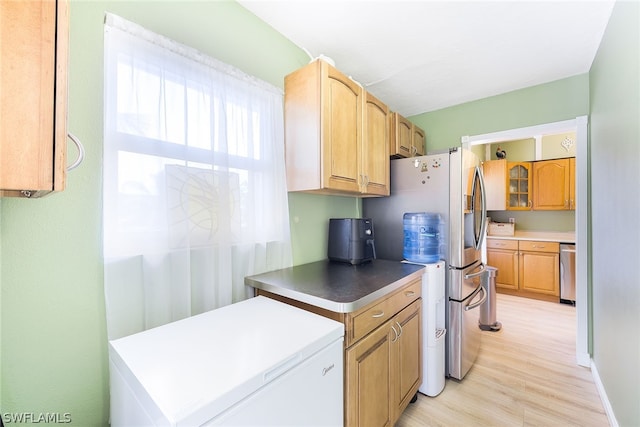 kitchen with stainless steel dishwasher, refrigerator, and light wood-type flooring