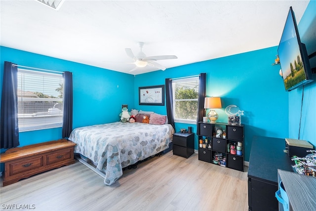 bedroom with light hardwood / wood-style flooring and ceiling fan