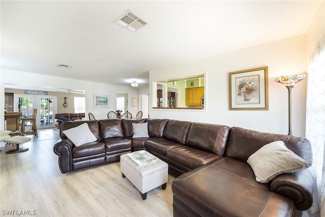 living room with light hardwood / wood-style flooring and french doors