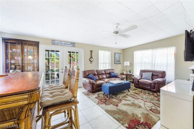 tiled living room featuring ceiling fan and french doors