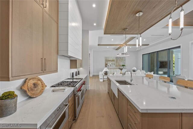 kitchen featuring a spacious island, double oven range, a sink, and decorative light fixtures