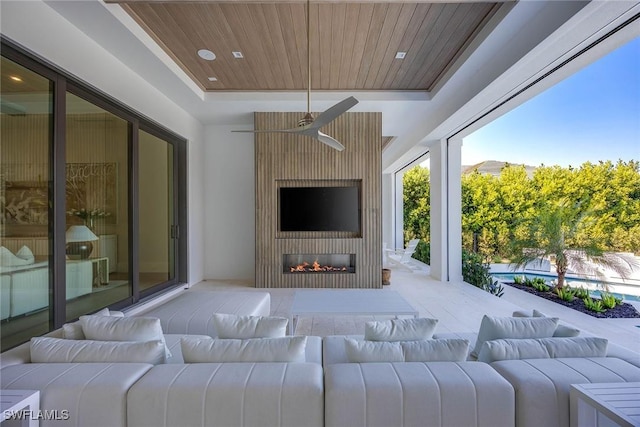 interior space featuring an outdoor pool, ceiling fan, and an outdoor living space with a fireplace