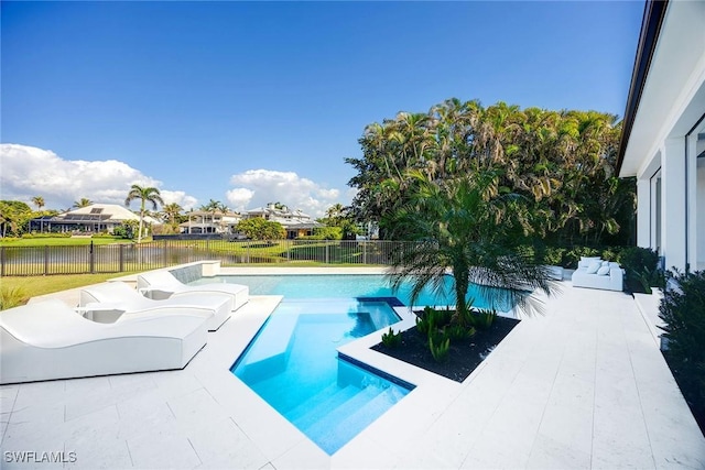 view of swimming pool featuring a patio, a water view, fence, and a pool with connected hot tub