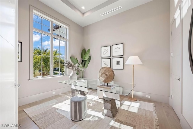 home office with baseboards, visible vents, and light wood finished floors