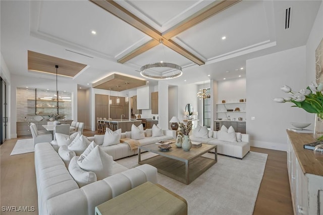 living area with recessed lighting, a notable chandelier, coffered ceiling, light wood finished floors, and beamed ceiling