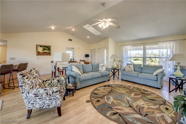 living room with light hardwood / wood-style flooring, ceiling fan, and lofted ceiling