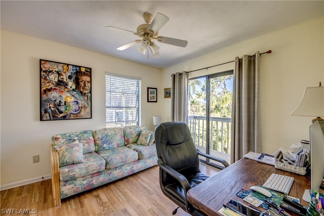 office with light hardwood / wood-style flooring and ceiling fan