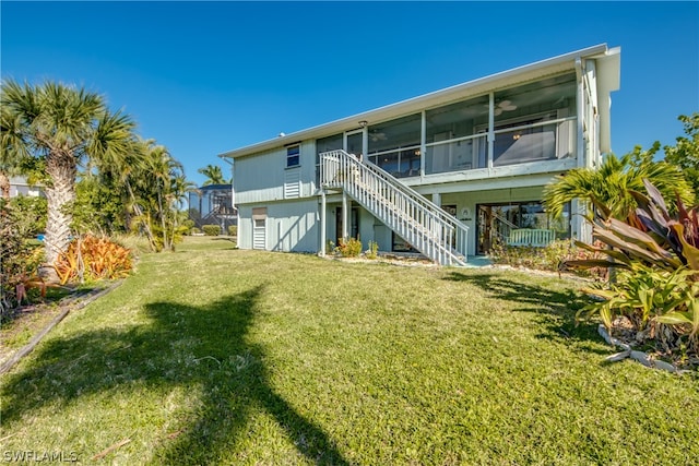 rear view of property with a yard and a sunroom