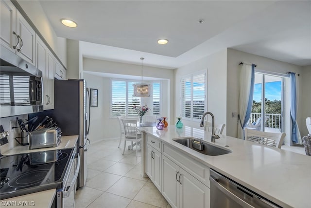 kitchen with white cabinetry, light tile flooring, appliances with stainless steel finishes, sink, and pendant lighting