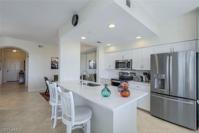 kitchen featuring white cabinets, light tile floors, appliances with stainless steel finishes, and sink